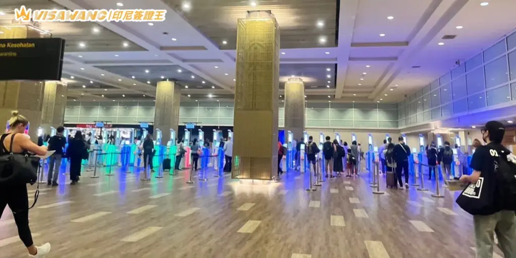 畫面拍攝於峇里島機場入境大廳,可見大量旅客使用電子自動通關閘門(e-Gate)進行入境審查,現場燈光明亮且通道整齊,呈現使用電子簽證快速通關的實際情況。適合用於介紹峇里島 e-Gate 使用方式、印尼電子簽證快速入境流程與機場通關教學相關內容。